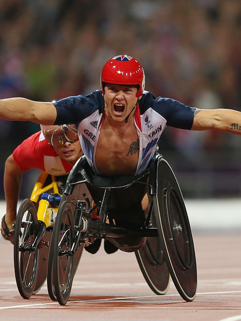 Wheelchair racer celebrates crossing finish line