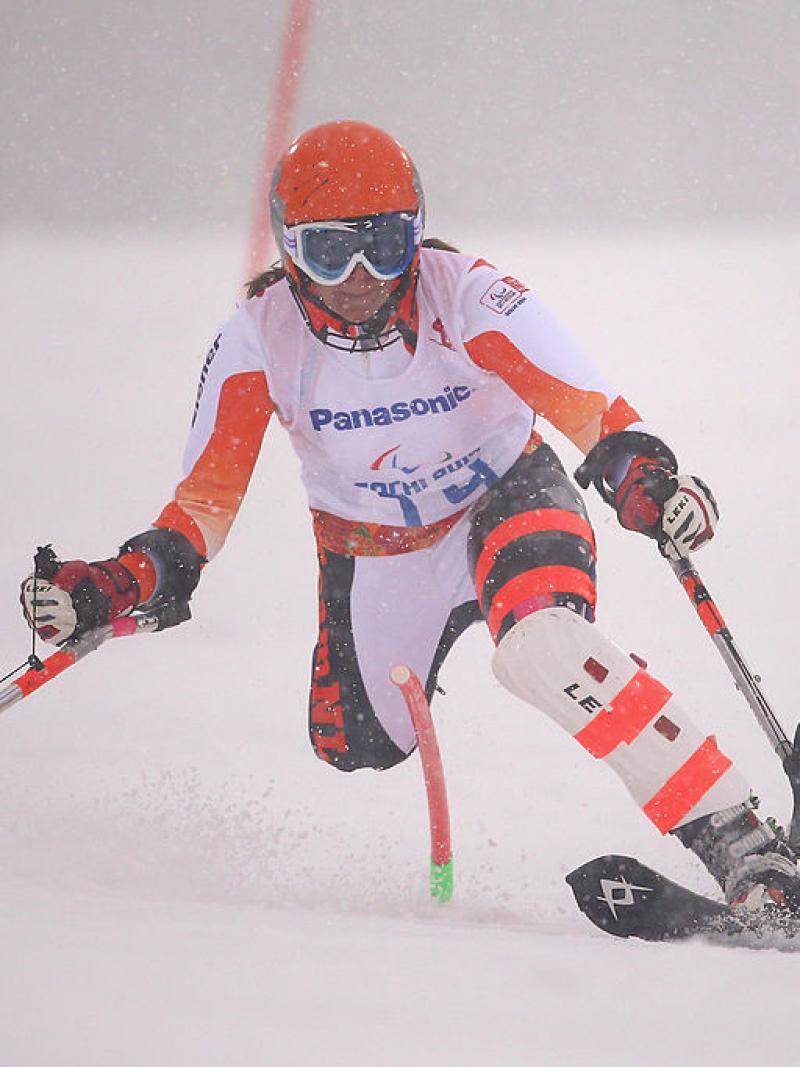 female alpine skier slaloms through gate