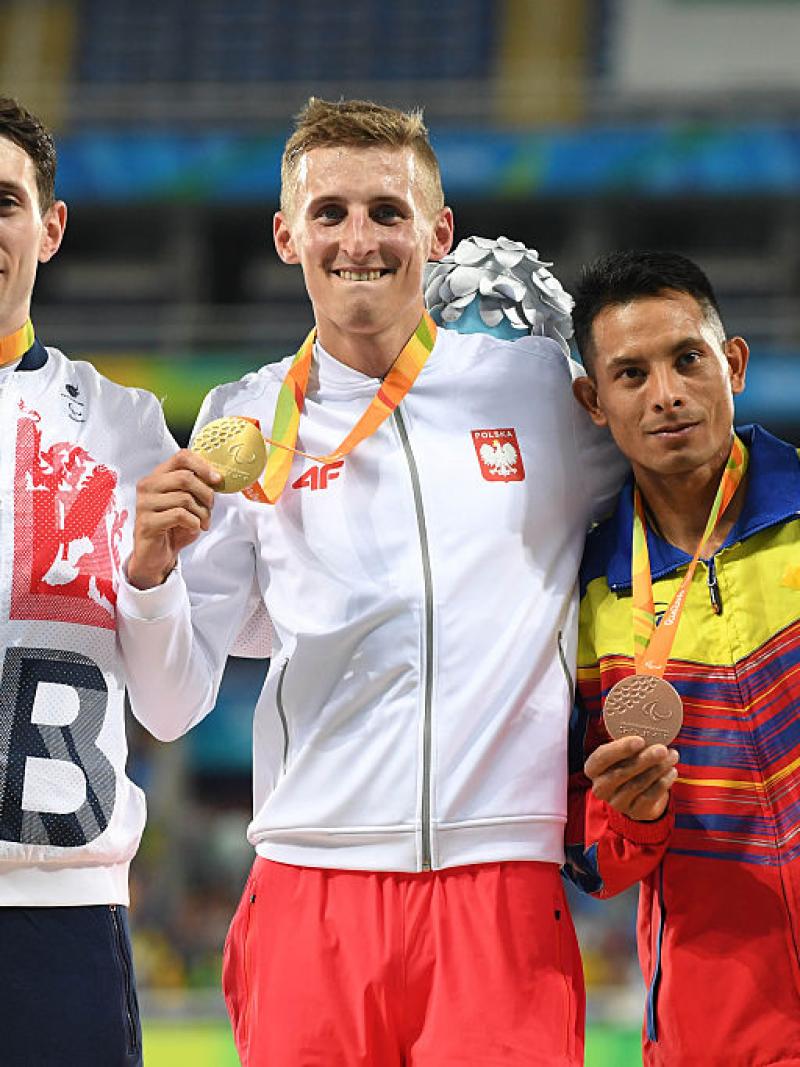 three men with medals on the podium