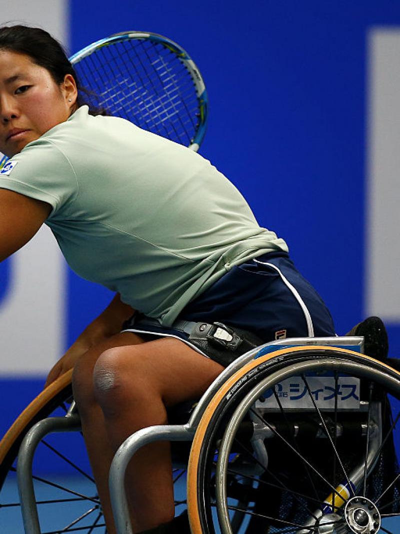 female wheelchair tennis player hits a backhand