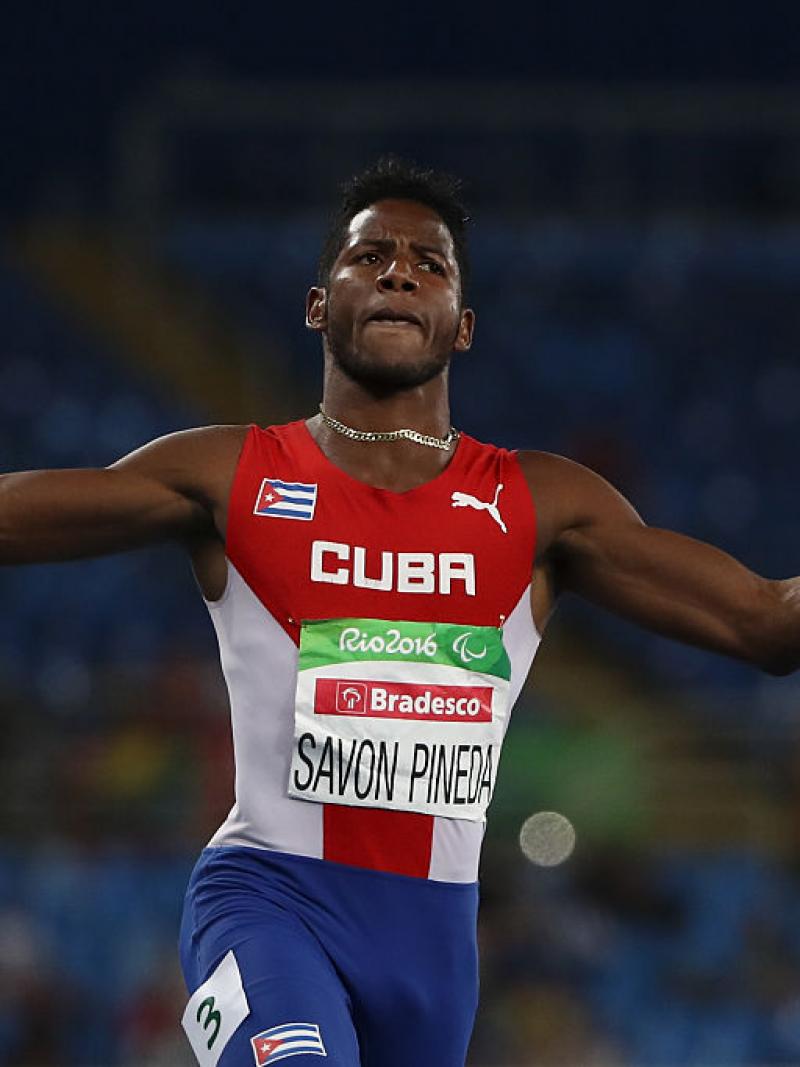 male sprinter crosses finish line with arms outstretched