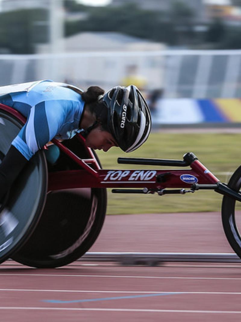 female wheelchair racer on track with head down