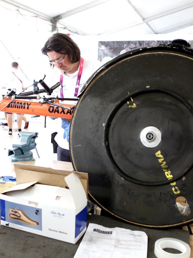 men repairing racing wheelchair