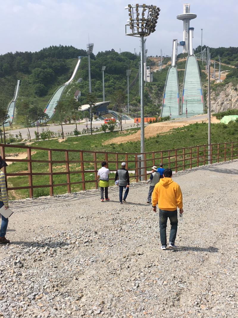 snowless skiing course being inspected by two men