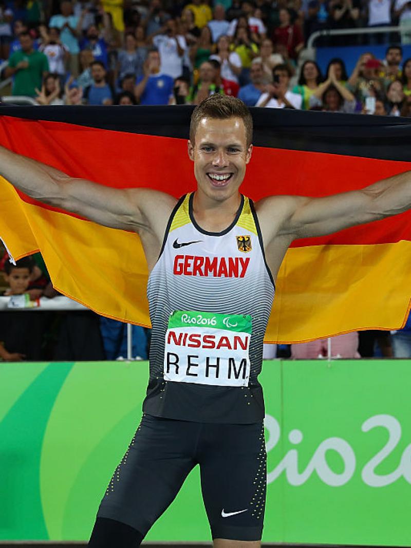 Man holds up German flag and smiles