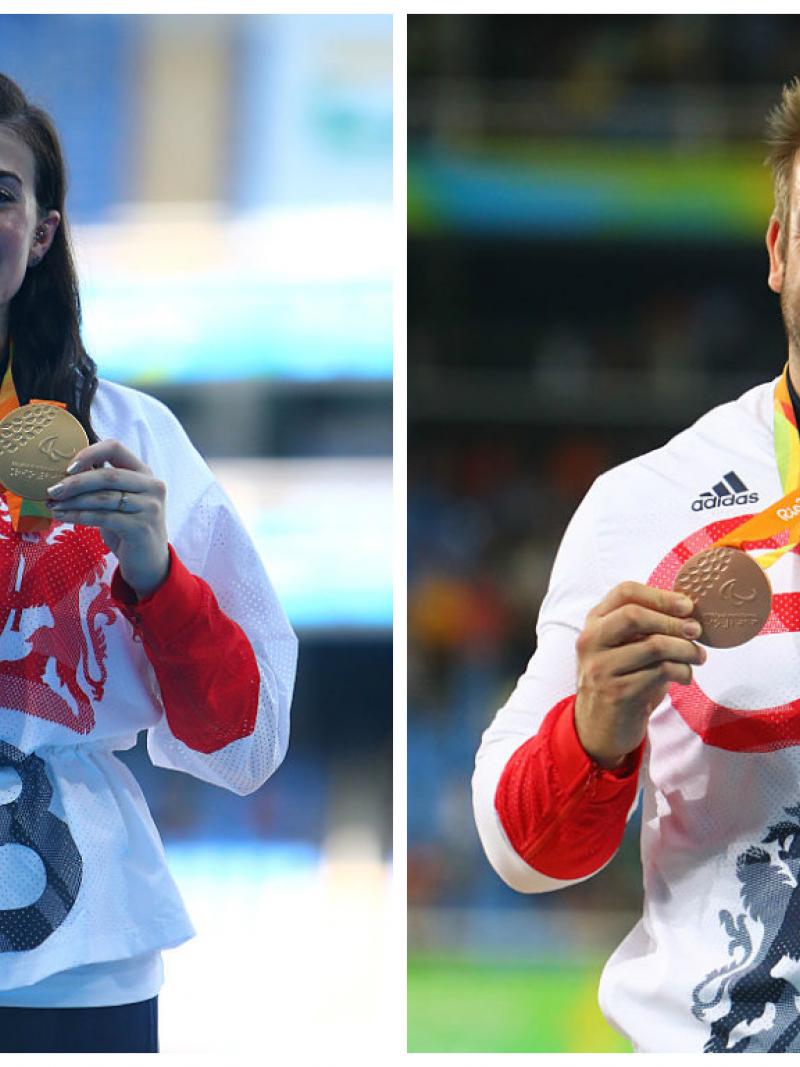 A male and female athlete stand on a podium holding their medals