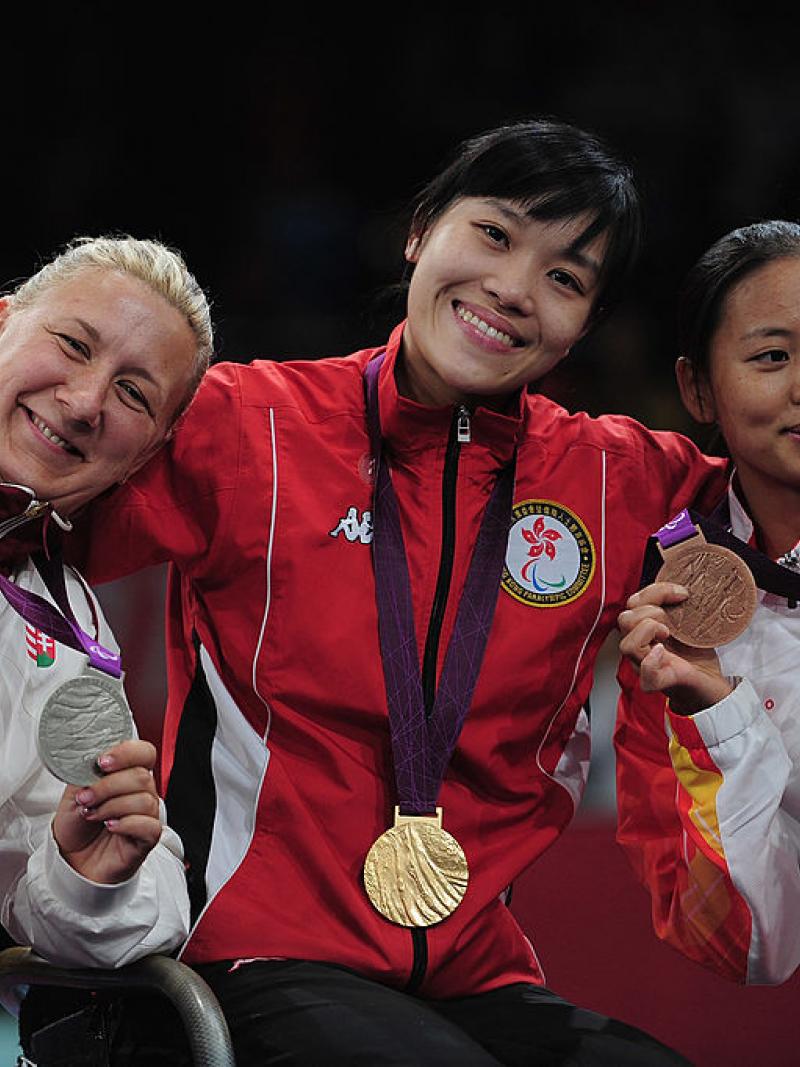 three women with medals standing on a podium