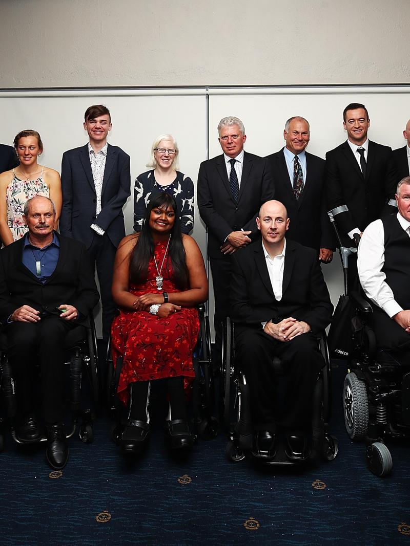 a group of athletes in evening dress smile for the camera