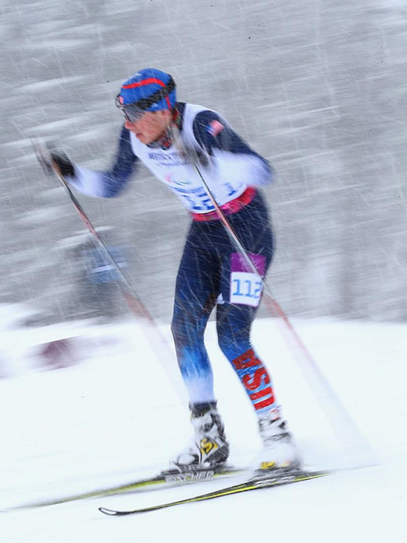 a man uses skies and poles to get across the snow