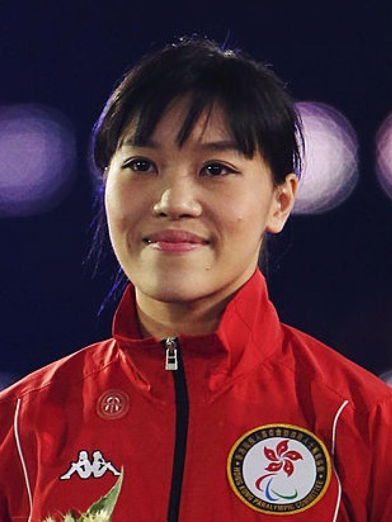 A woman stands and smiles for the camera