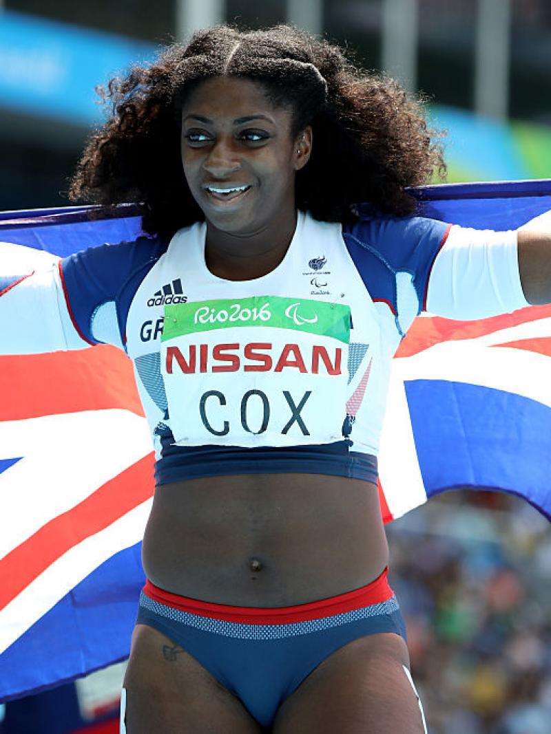 a female para athlete holds up a British flag
