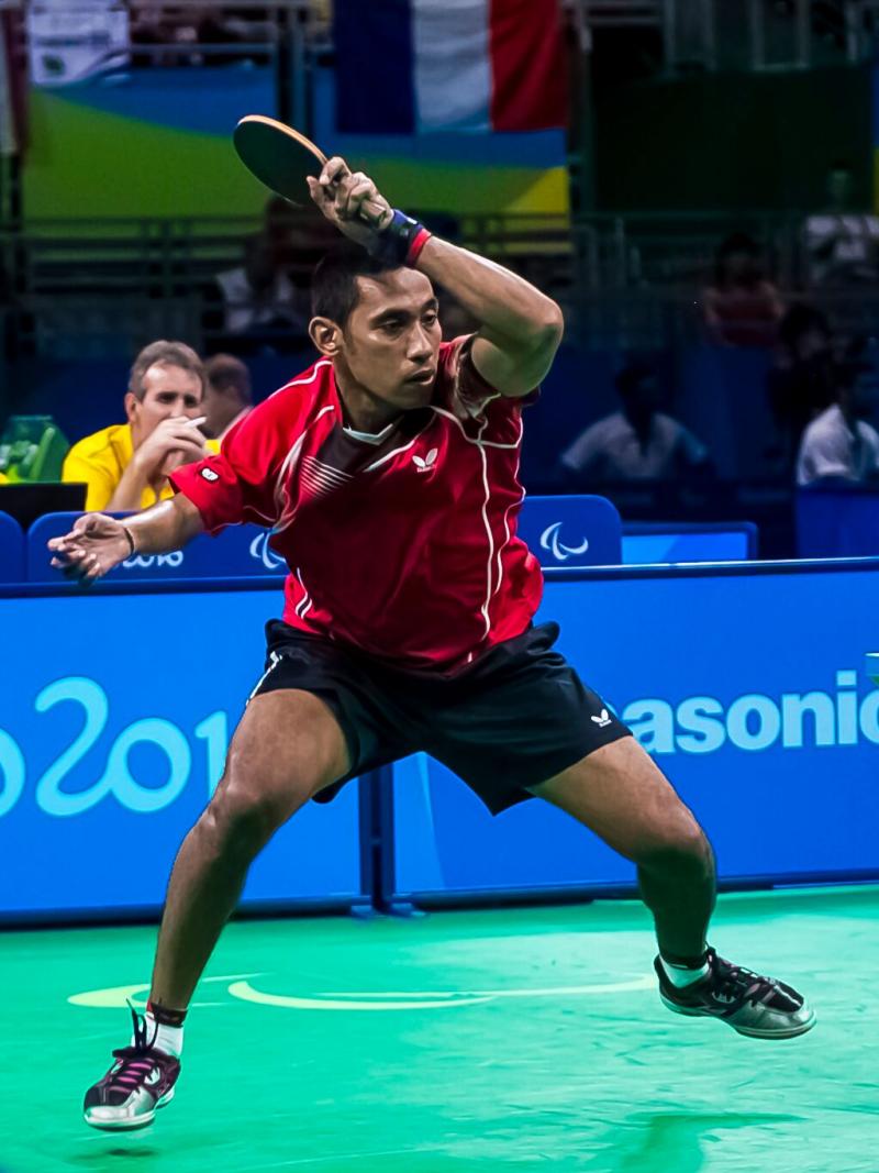 a para table tennis player hits the ball across the net