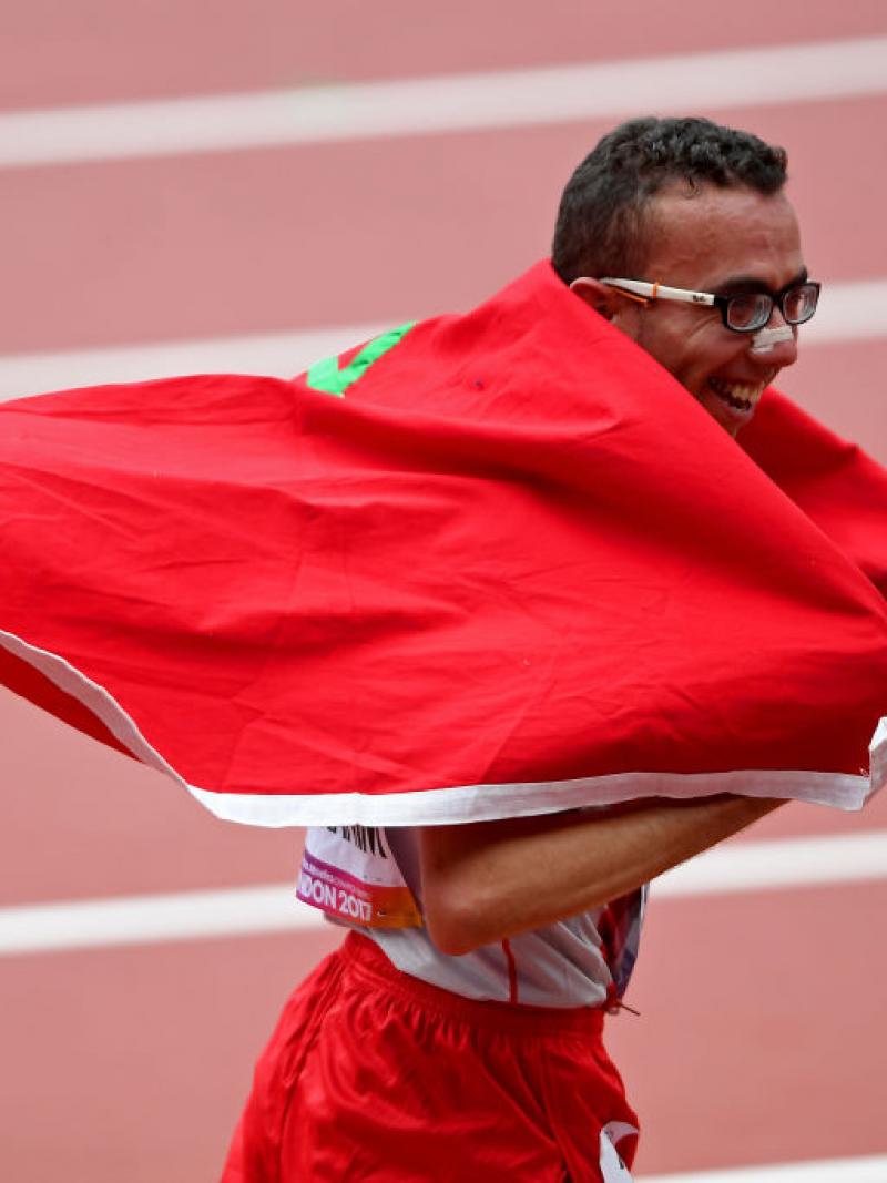 Man in running clothes celebrates with Morocco flag