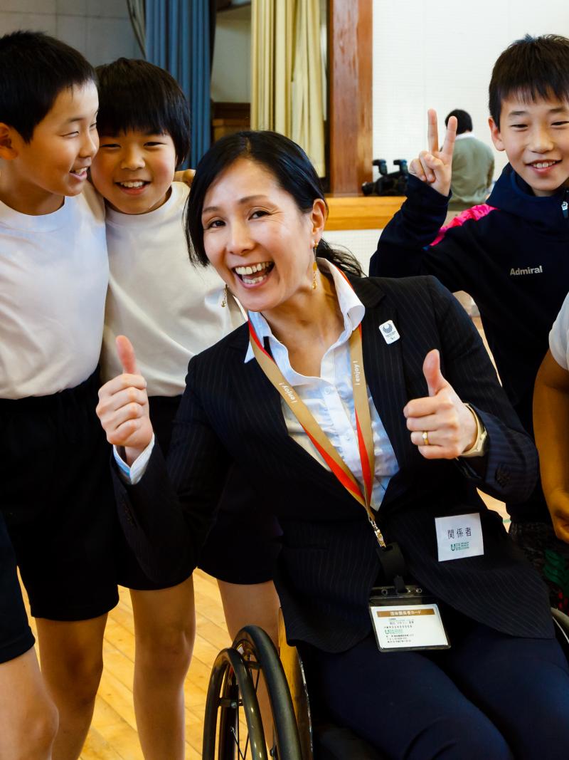 A group of children pose with a wheelchair athlete