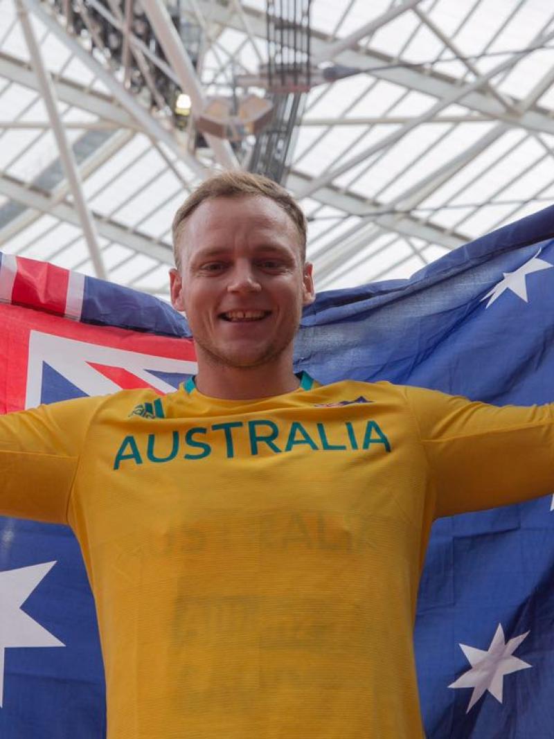 An athlete poses with the Australia flag after winning gold