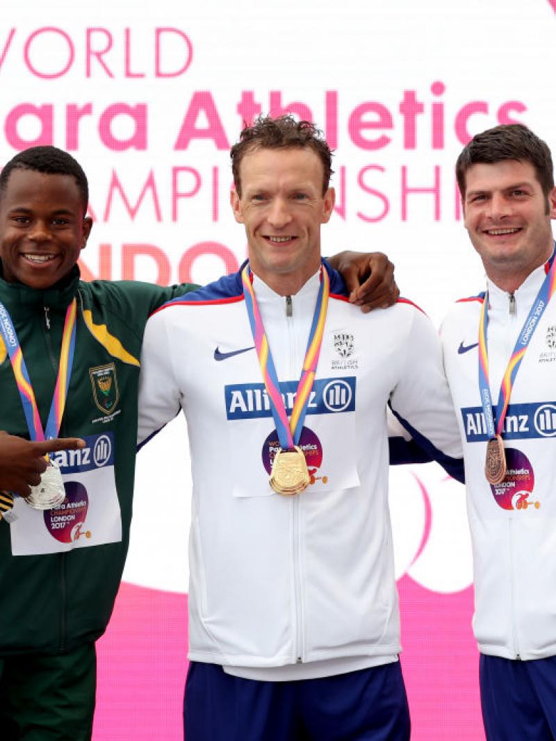 three men stand on the podium with their medals