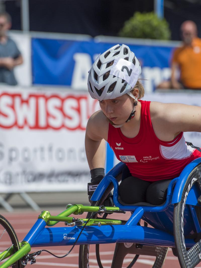 a female wheelchair racer lines up for the start of a race