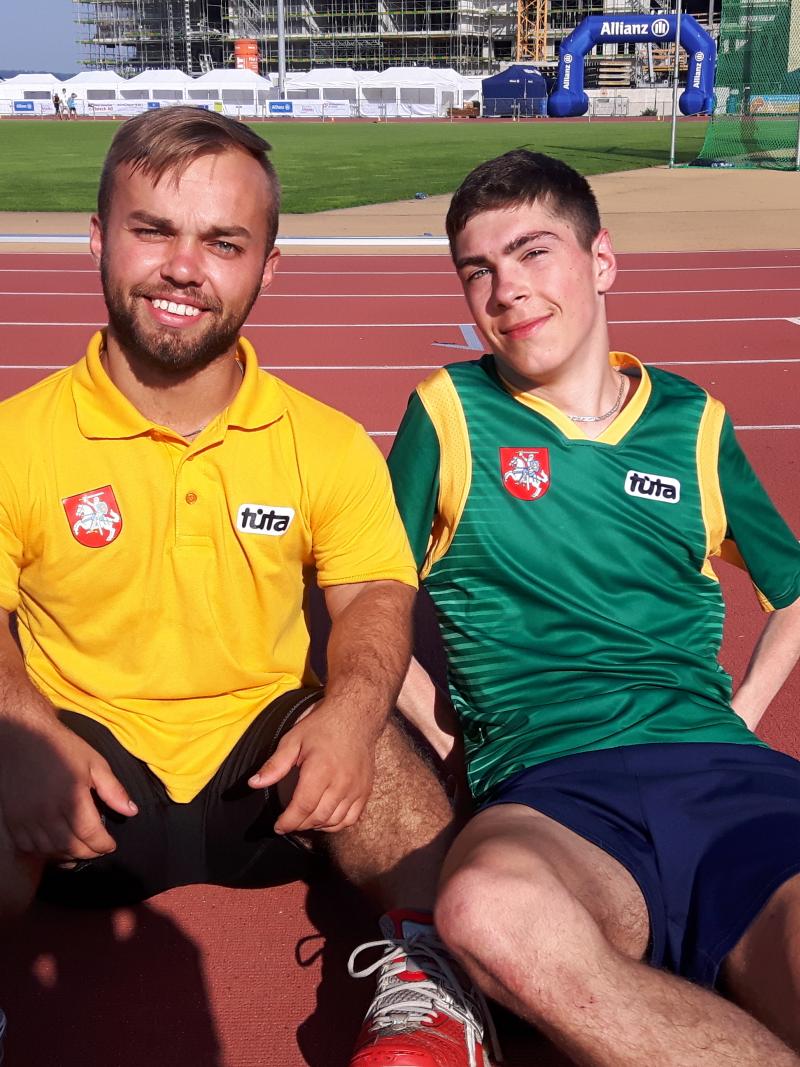 two male para athletes sit together on the track