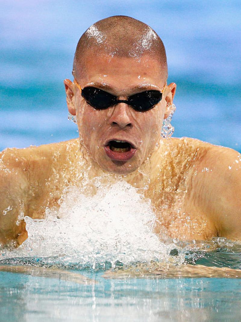 a para swimmer comes out of the water to take a breath
