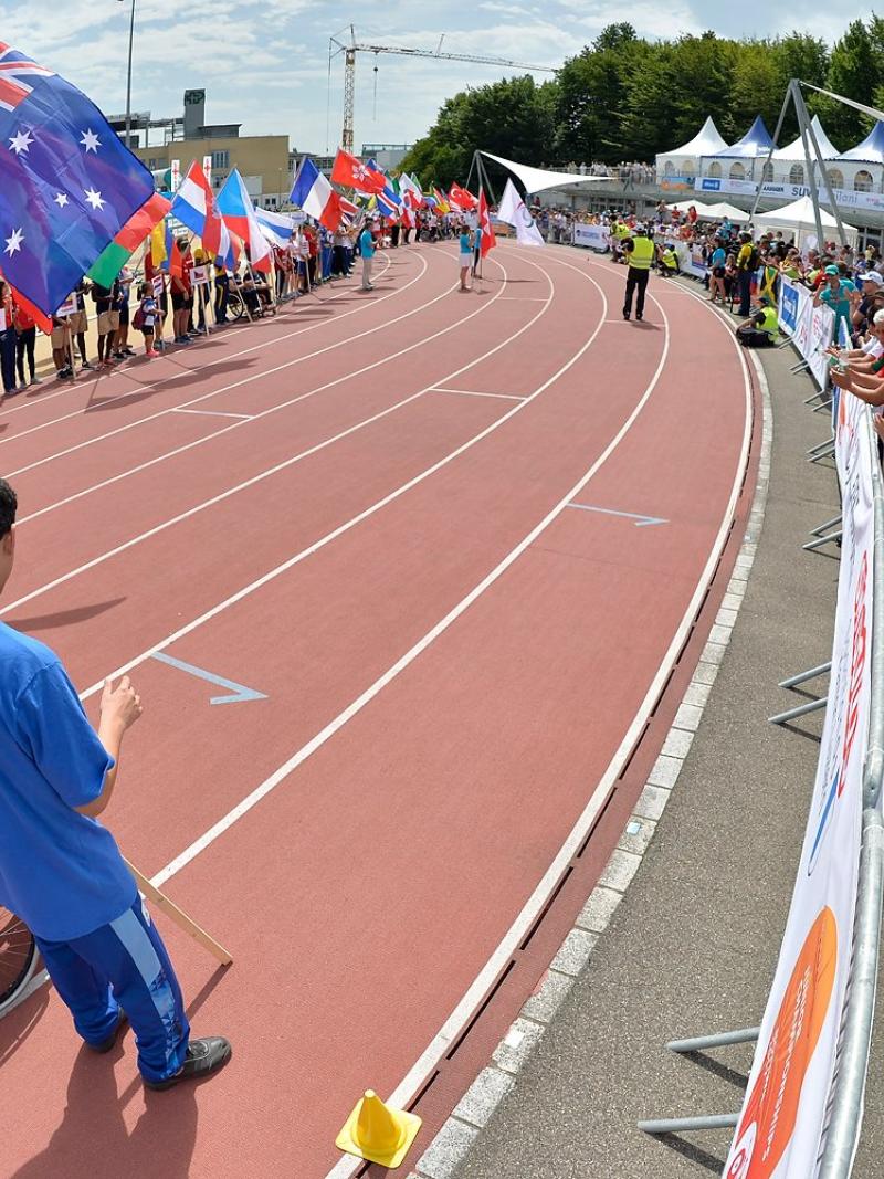 Teams holding flags on the track for Opening Ceremony