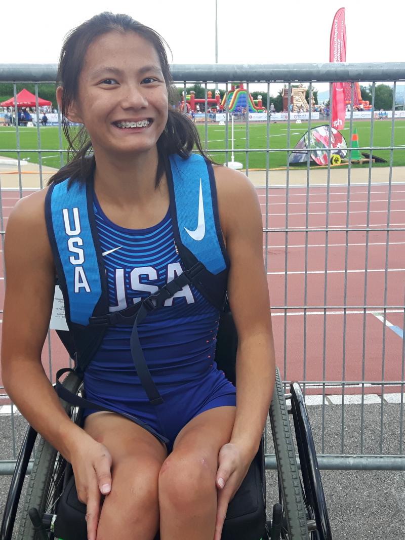 Girl in wheelchair smiles for a photo after her race