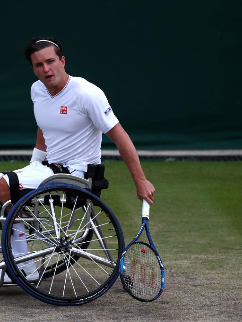 a wheelchair tennis player hits a shot