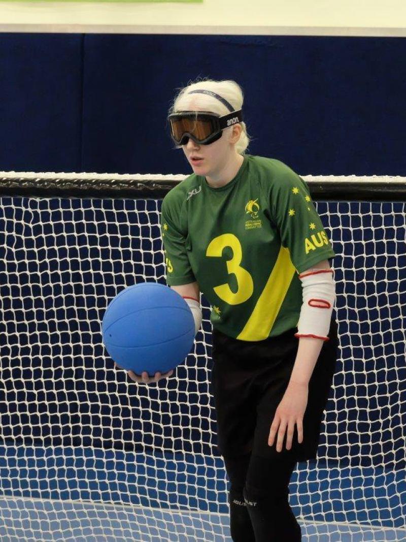 A female goalball player holds the ball