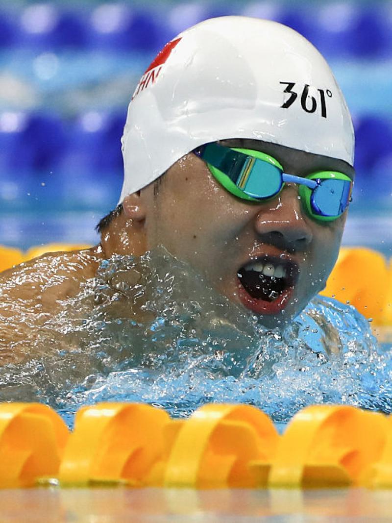 a Para swimmer takes a breath out of the water