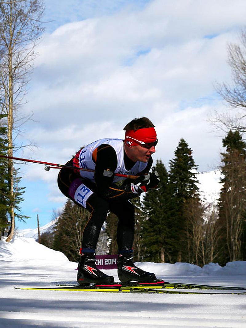 A male Para cross country skier skies across the snow