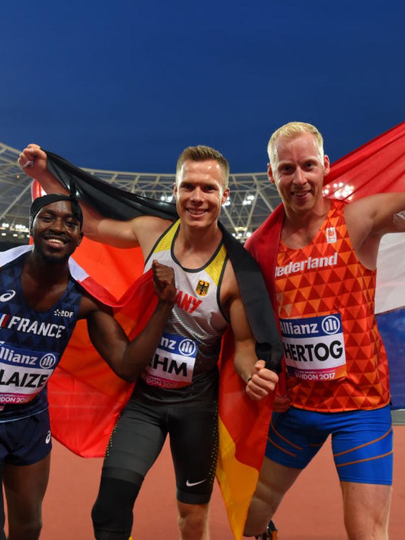 three men celebrate with the flags of their countries