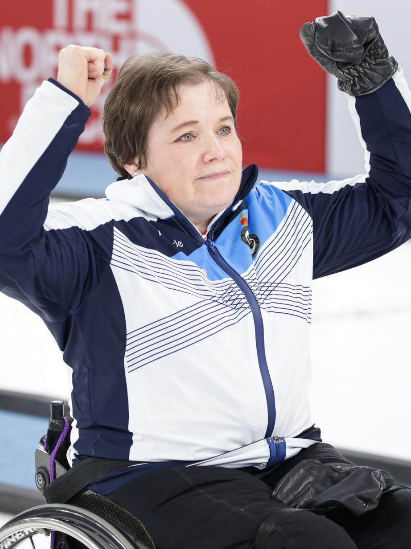 Female wheelchair curler raises her arms