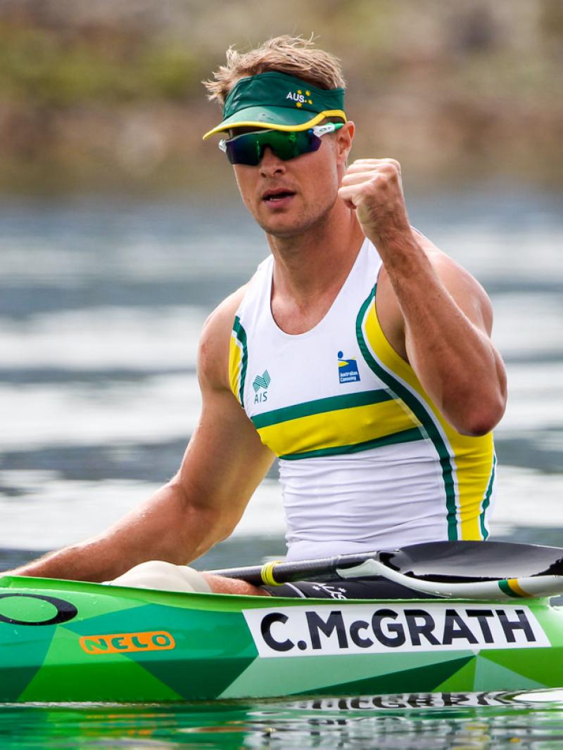 Man in canoe pumps his fist after winning