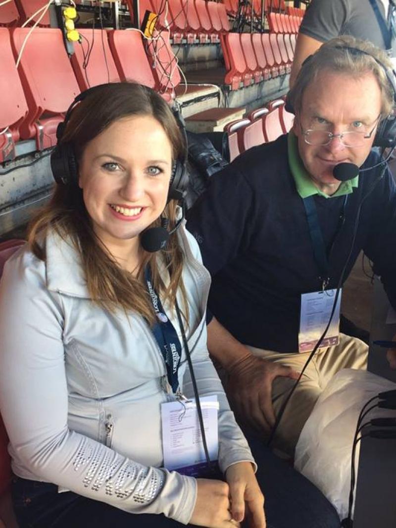 a man and a woman sit in a commentary box