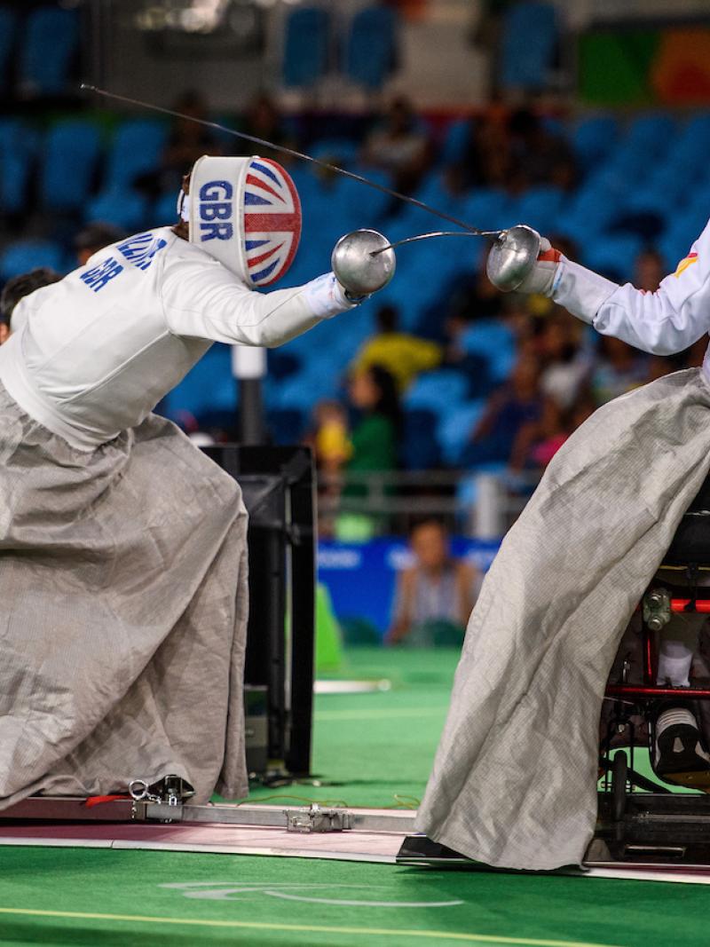 two wheelchair fencers mid bout