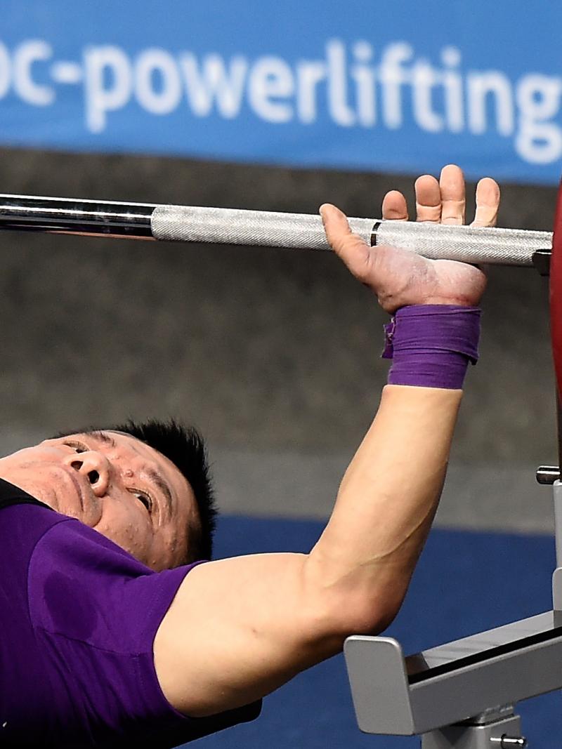 Man lays on bench preparing to bench press.
