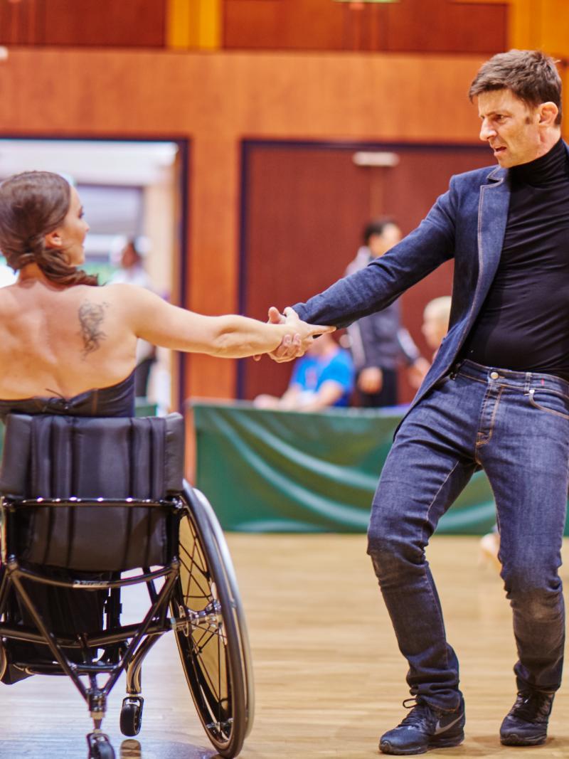 Woman wheelchair dancer and her standing partner perform