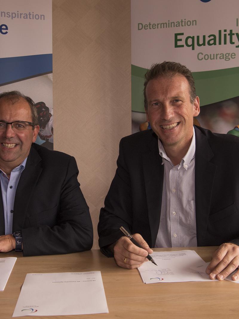 Two men signing a contract