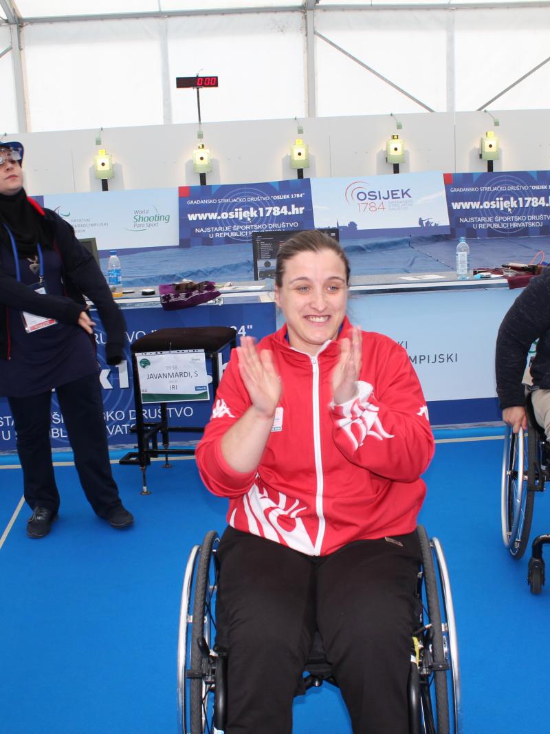 Female shooter in wheelchair smiles after winning