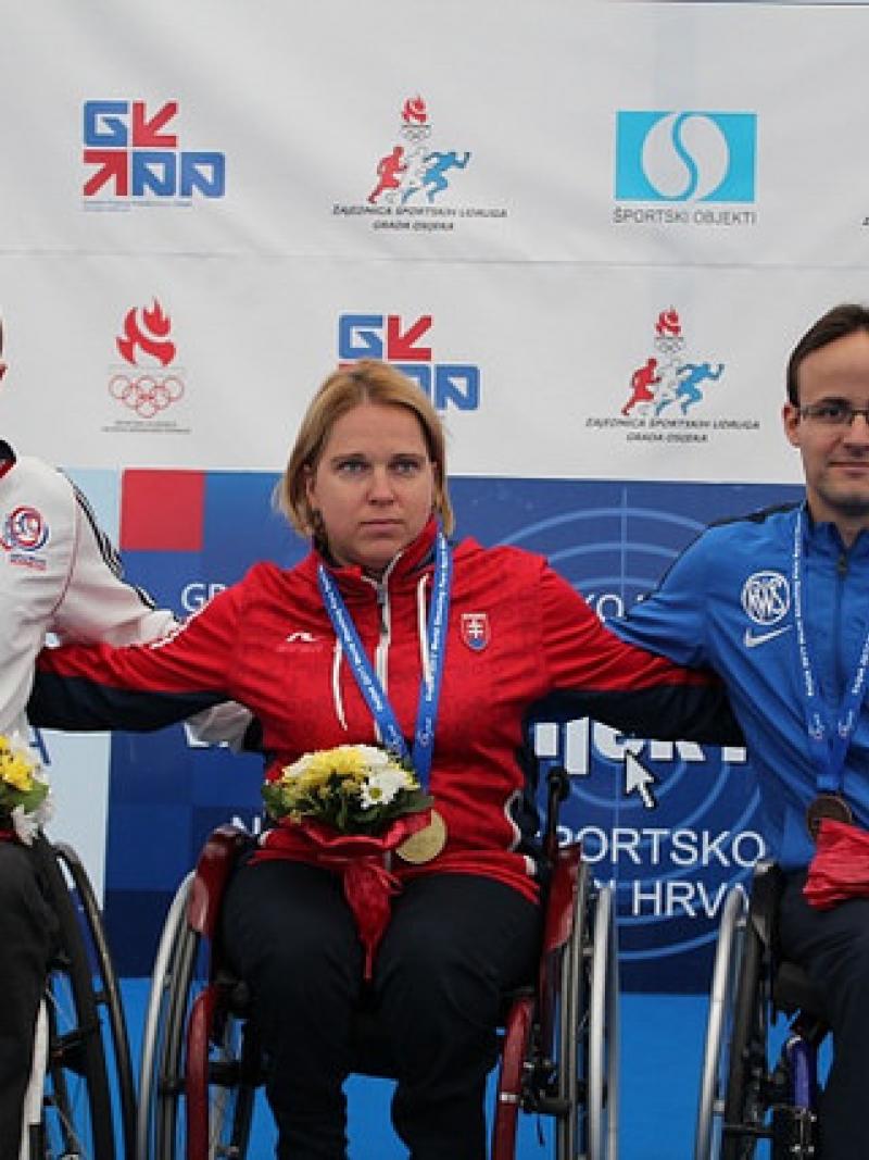 a group of three wheelchair athletes on the podium
