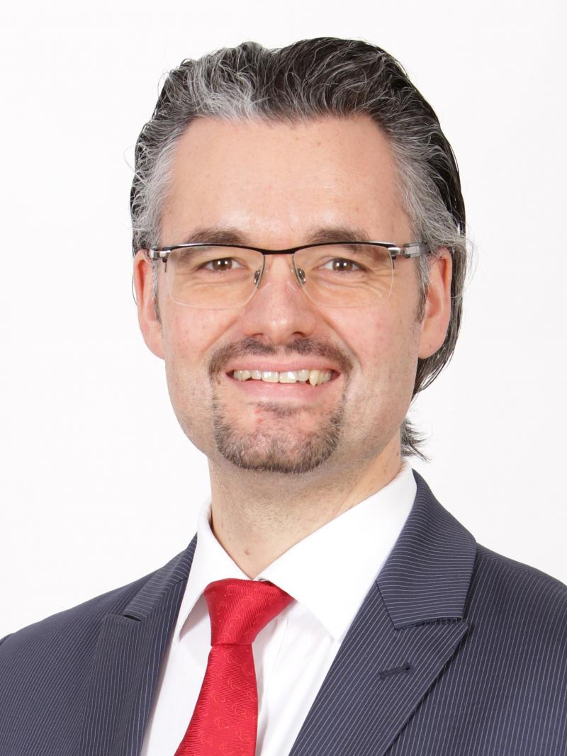 a man in a suit smiles for the camera