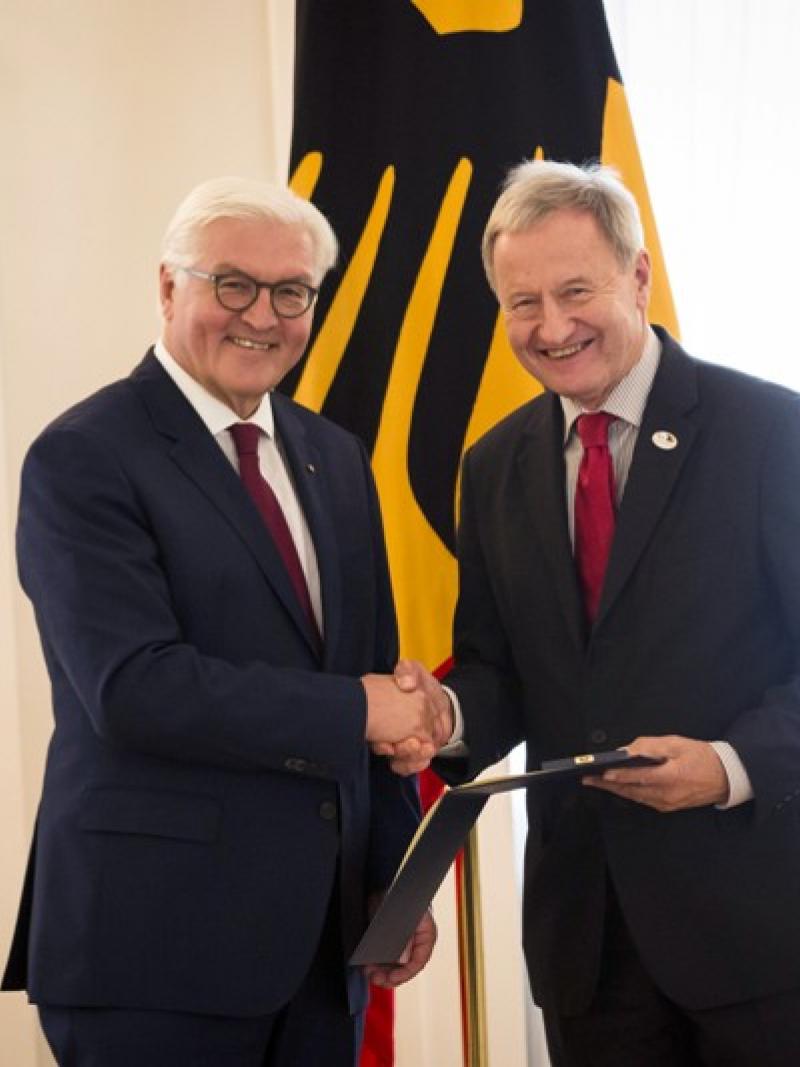two men shaking hands and smiling
