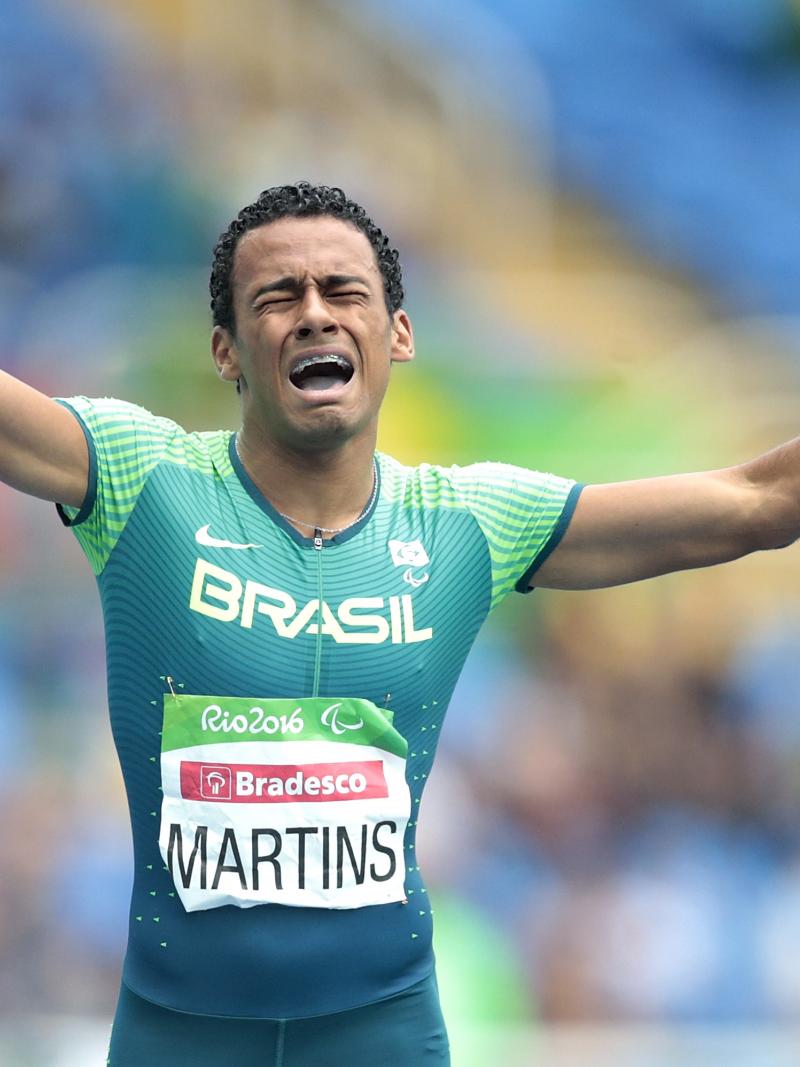 a Para athlete cries out in celebration as he crosses the finish line