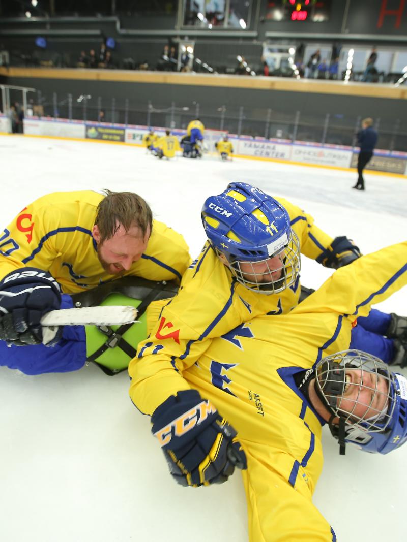 Para ice hockey players celebrate on the ice