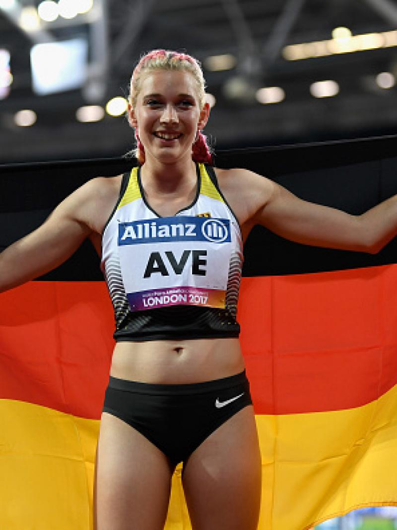 Person smiling and posing with the flag of Germany