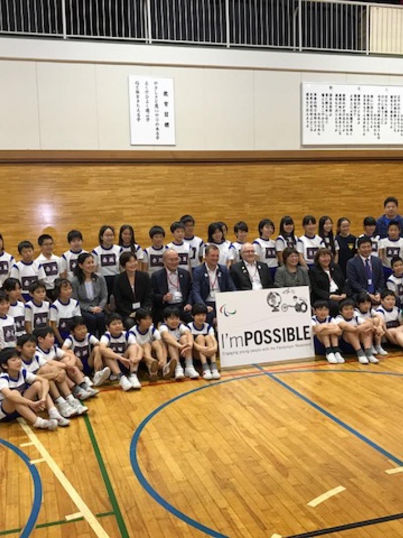 Children from the Akasaka Elementary School pose for picture in a goalball court with representatives from the IPC, NPC Japan and Nippon Foundation