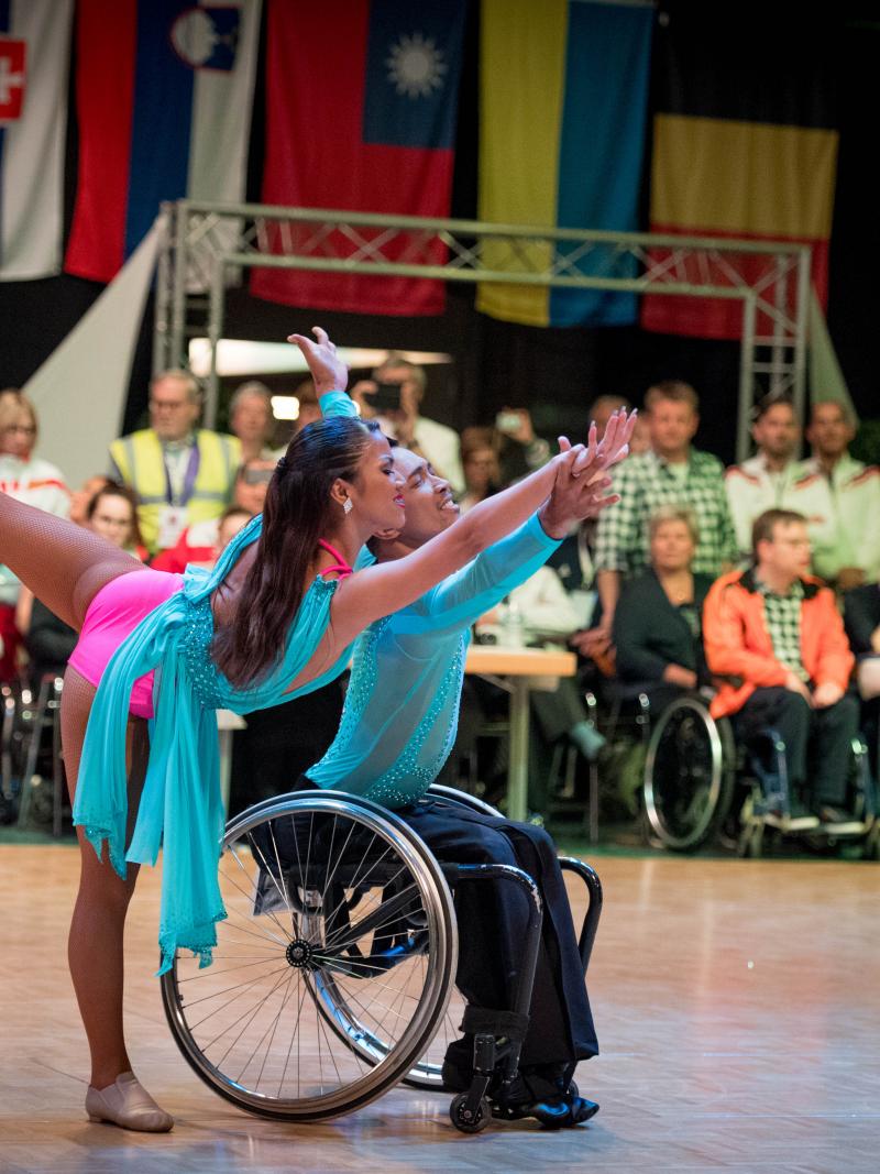 Man in wheelchair and woman standing dancer dance