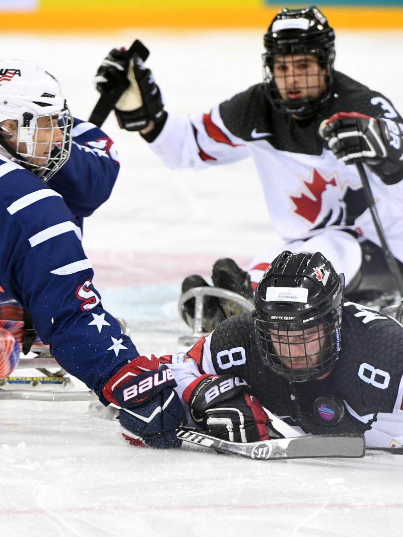 Para ice hockey players contest a puck
