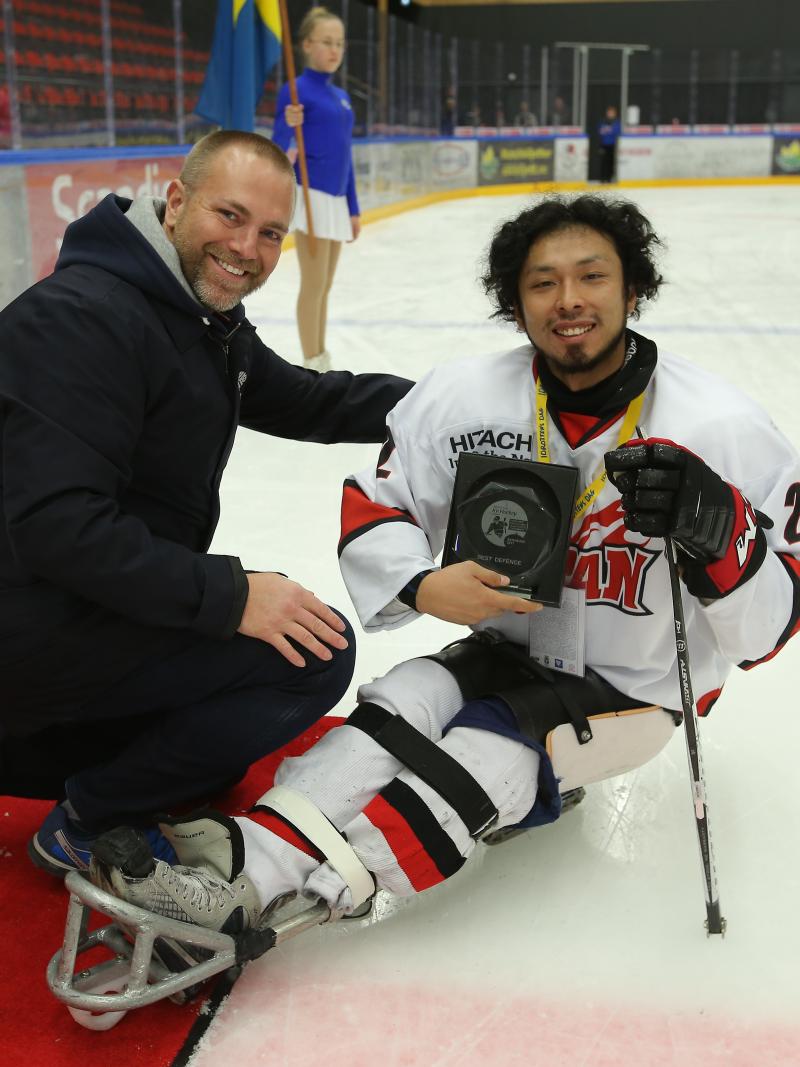 a male Para ice hockey player smiles after being presented with an award