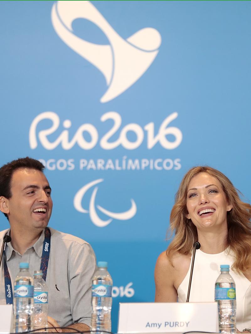 a man and a woman answering questions at a press conference