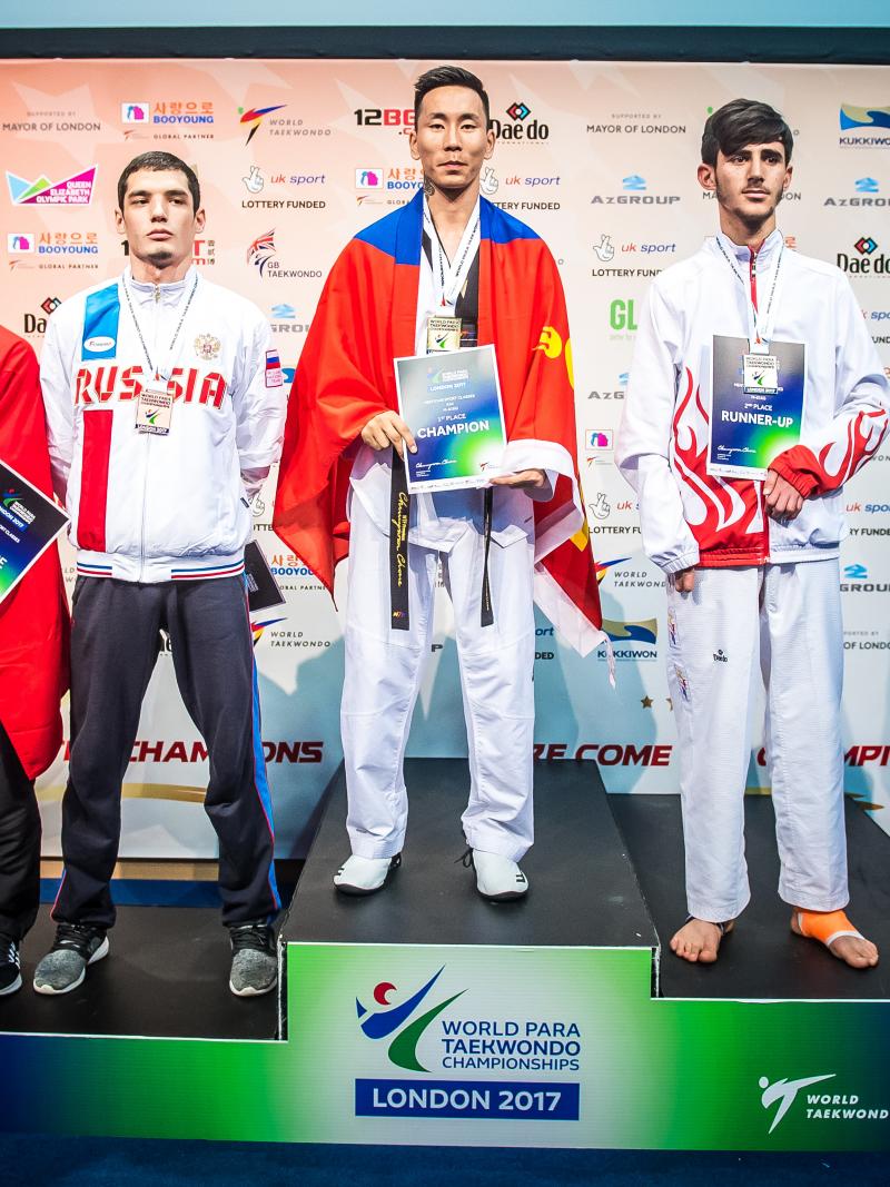 a group of Para taekwondo fighters stand on the podium